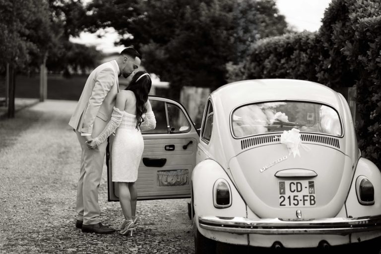 Un couple de mariés devant leur voiture