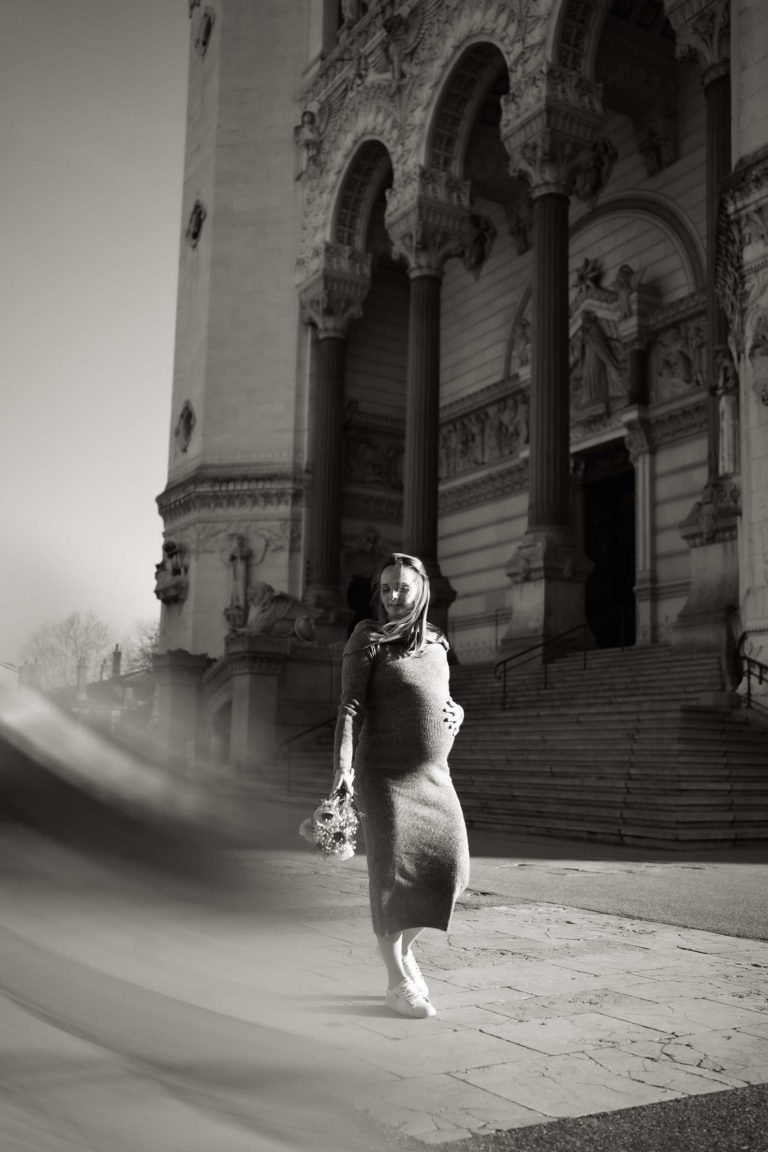 Une future maman qui marche devant une cathédrale