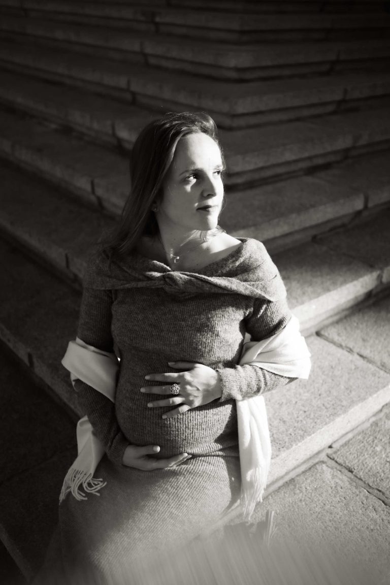Une future maman assise sur des escaliers